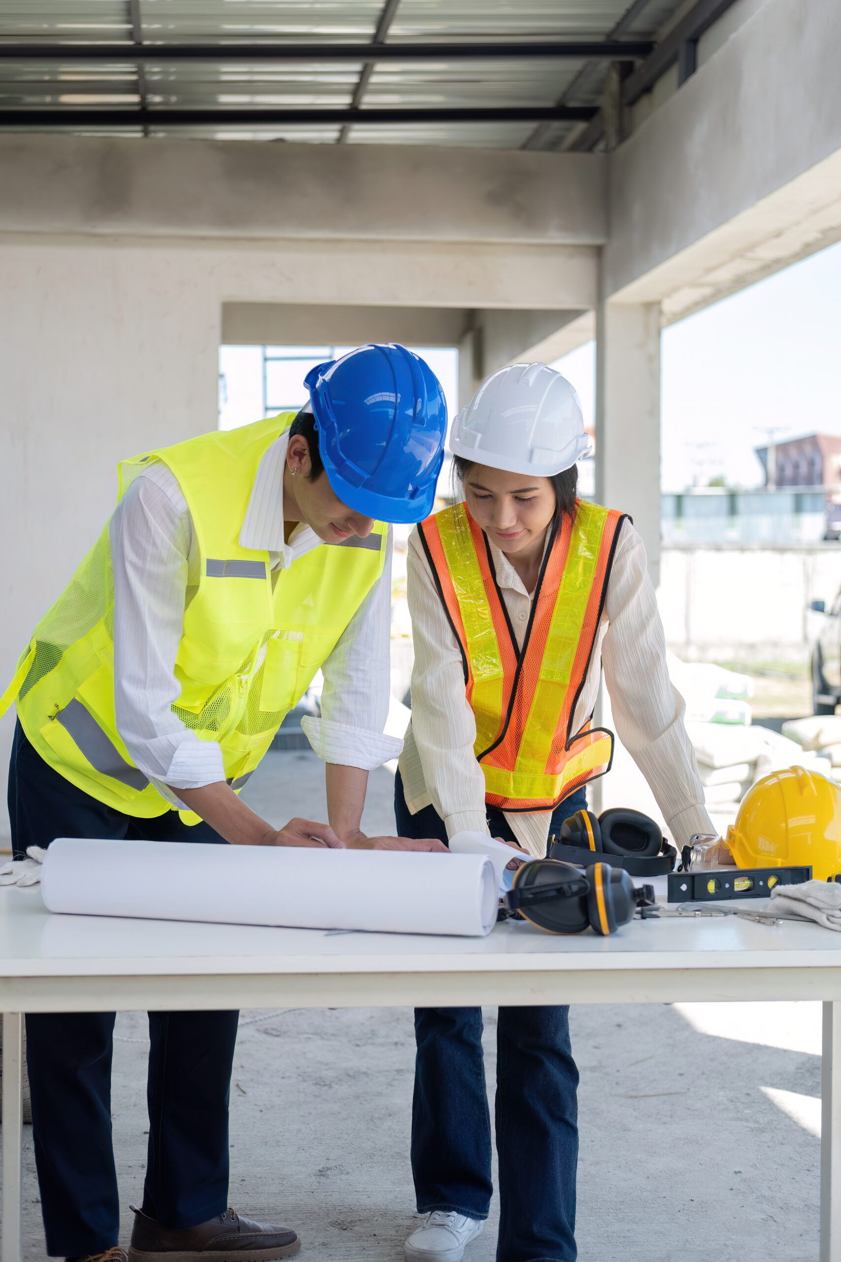 civil engineer teams meeting working together wear worker helmets hardhat on construction site in modern city. foreman industry project manager engineer teamwork. asian industry professional team